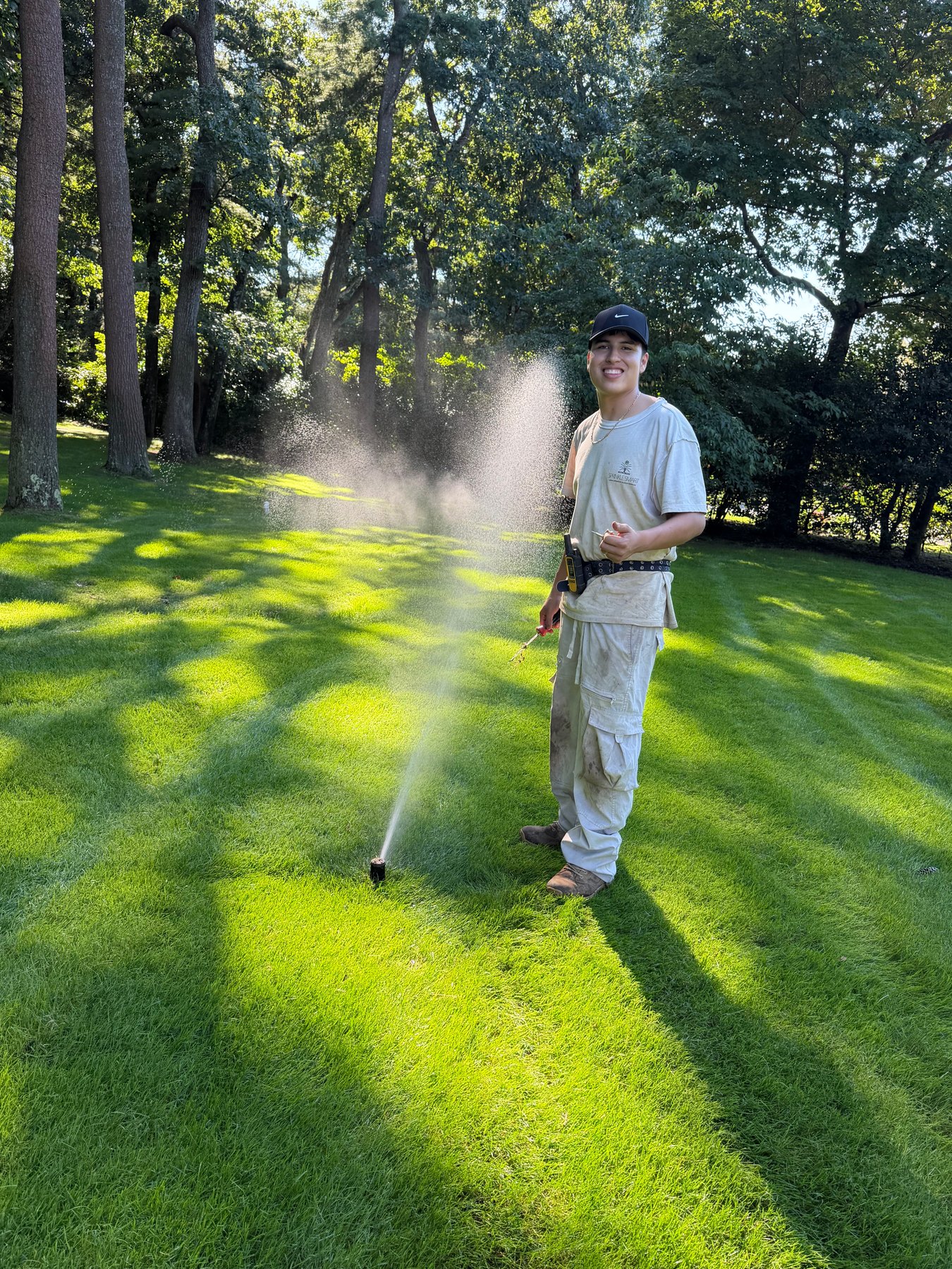Smiling Sprinkle Smart team member servicing a sprinkler system